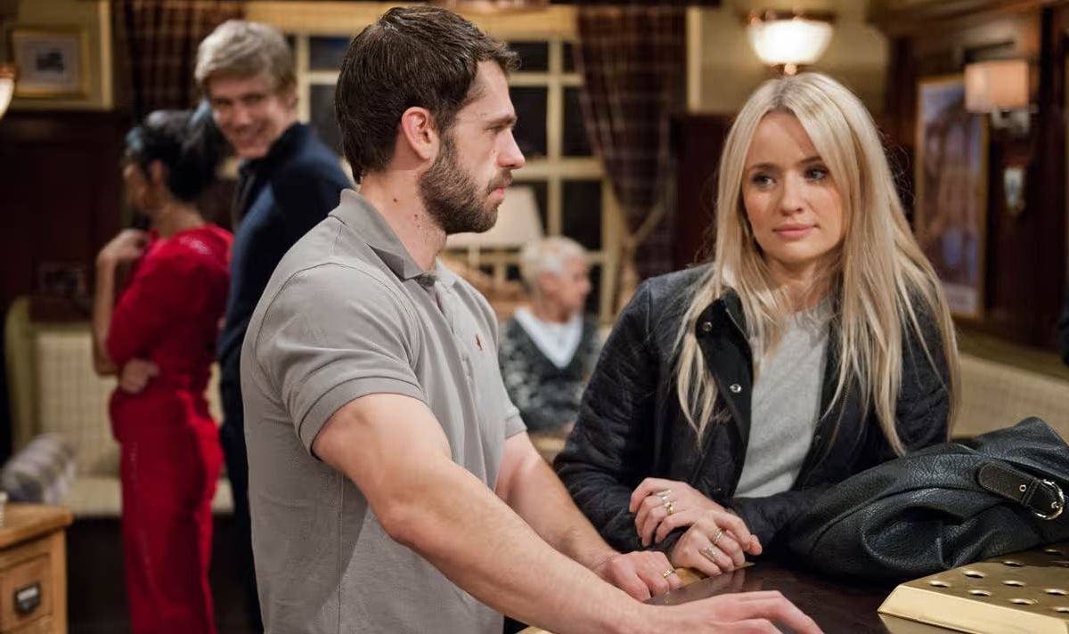 A woman and a man standing at a bar.