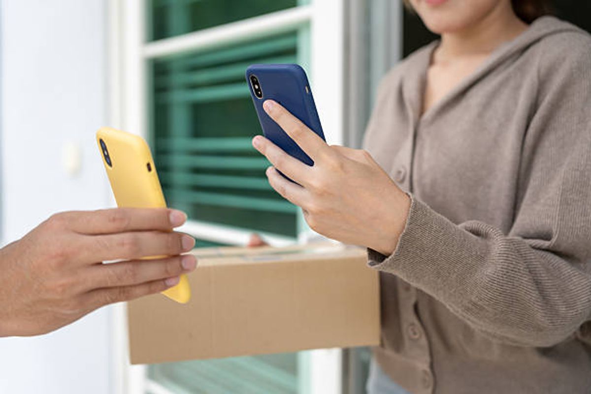 Woman receives boxes parcel from courier in front house (file image)