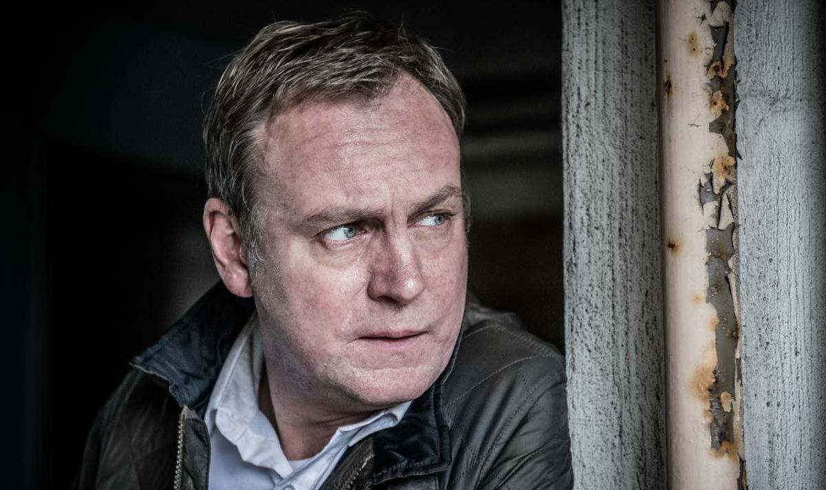 A man in a coat and shirt.