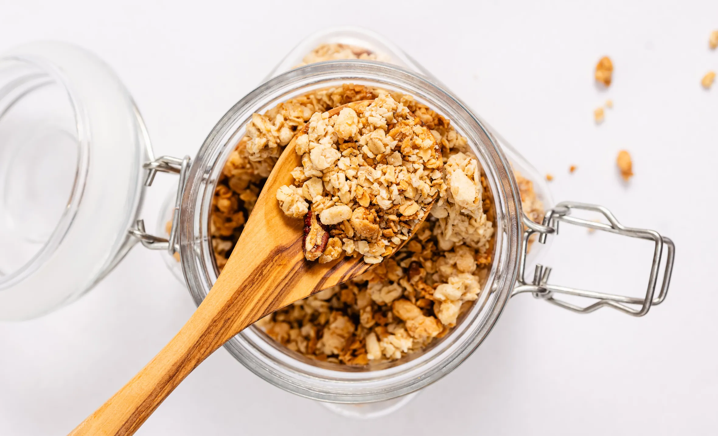 Jar of granola and wooden spoon, overhead view