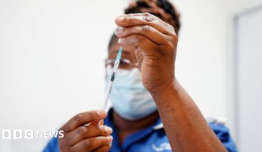 A nurse draws up a dose of vaccine into a syringe