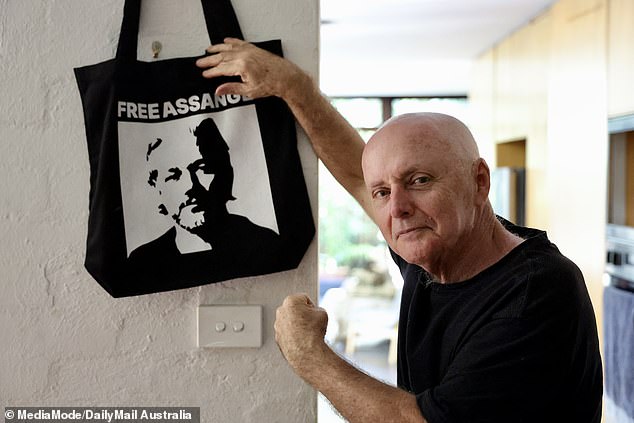 Mr Mobbs pictured with a tote bag featuring Julian Assange, which hangs in his home