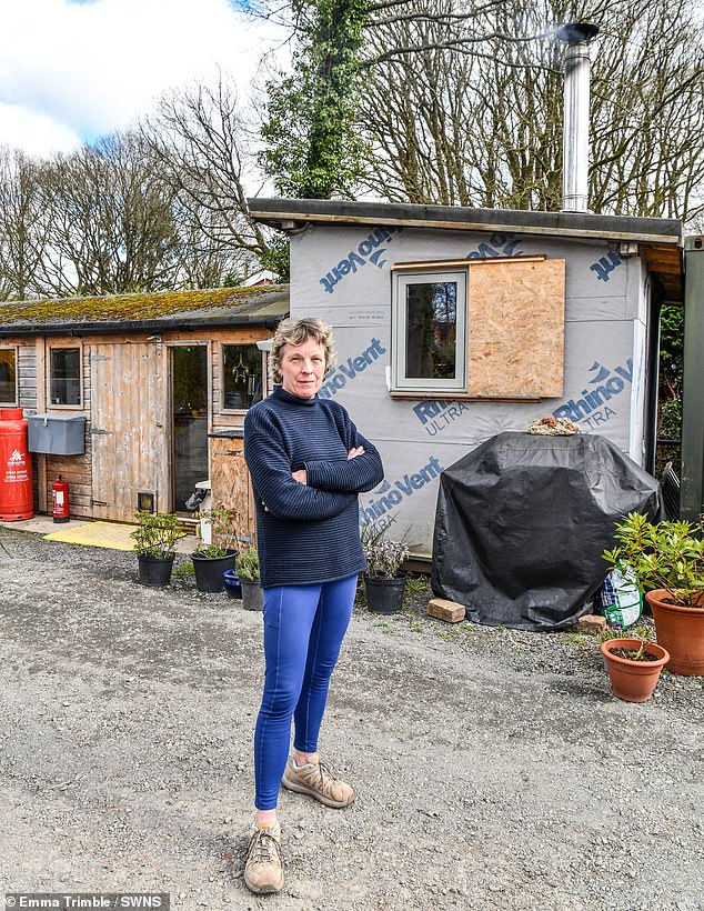 Jane Coyle, 64, and her husband Anthony, 67, submitted plans to build the three bedroom eco property in the village of Edwyn Ralph, Herefordshire, back in 2020. Pictured: Mrs Coyle outside the shed the couple have been forced to live in