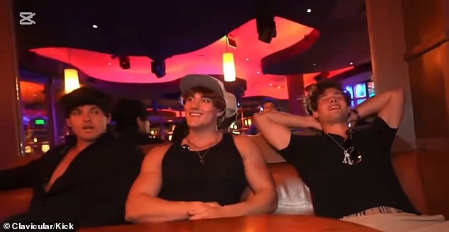 Clavicular (right) is seen on Tuesday evening's livestream at a bar in Miami. Moments after this, he slumped over on the table
