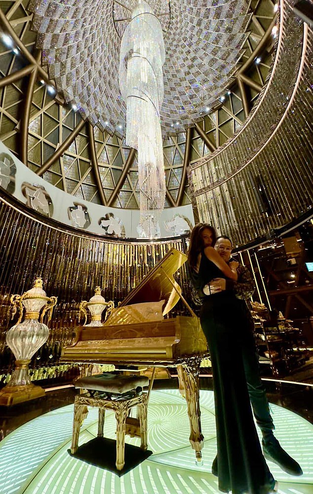 The pair pose beneath an opulent chandelier in a lavish interior beside a gold grand piano, as shared in another photo posted by Tong
