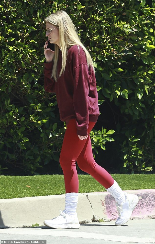 Trainor held a phone conversation while walking around the Encino neighborhood in red leggings and a cranberry-colored crew neck sweatshirt