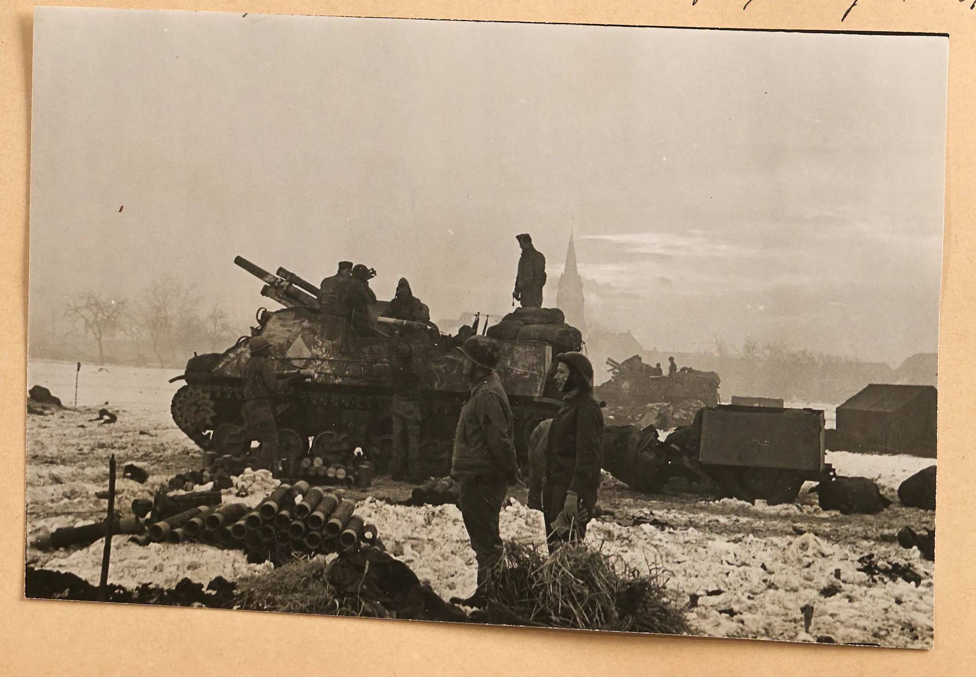 Photographs from the Miller-Beaton scrapbook, including Hitler's living room, a house, Eva Braun in bed reading Mein Kampf, the "Eagle's Nest" on fire, and soldiers next to a tank.
