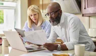 An older couple goes over papers together in their kitchen.