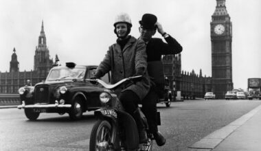 Moped navigating busy London street, highlighting urban transportation and city traffic dynamics