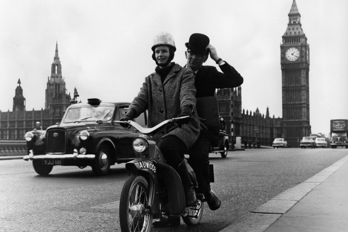 Moped navigating busy London street, highlighting urban transportation and city traffic dynamics