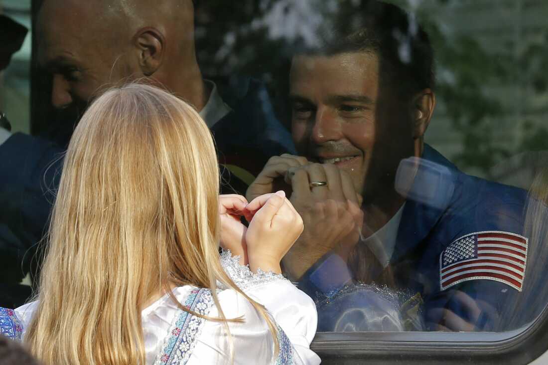 Reid Wiseman exchanges heart gestures with one of his daughters from a bus before his crew's rocket launched out of Kazakhstan in May 2014.  