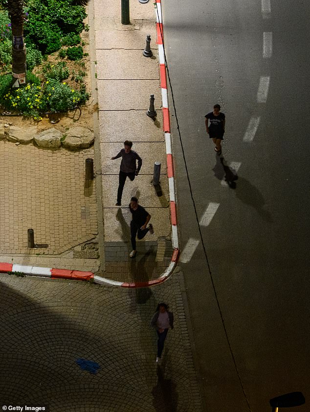 TEL AVIV, ISRAEL - APRIL 10: People run to take shelter as sirens sound during incoming missile fire, without an early warning, allegedly from Hezbollah, just after midnight on the third day of the U.S. Israel Iran Ceasefire on April 10, 2026 in Tel Aviv, Israel. These are the first sirens in Tel Aviv and the surrounding area since the ceasefire has begun. President Donald Trump announced a two-week ceasefire between the US and Iran on his Truth Social platform, conditional on shipping being allowed to resume through the Strait of Hormuz. The IDF has said it will observe the ceasefire with Iran but will continue military targeting Hezbollah in Lebanon. (Photo by Alexi Rosenfeld/Getty Images)
