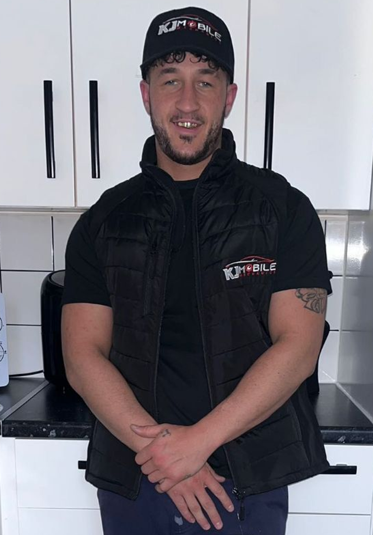 Mr Fletcher wearing a black cap, black T-shirt and black gilet and jeans