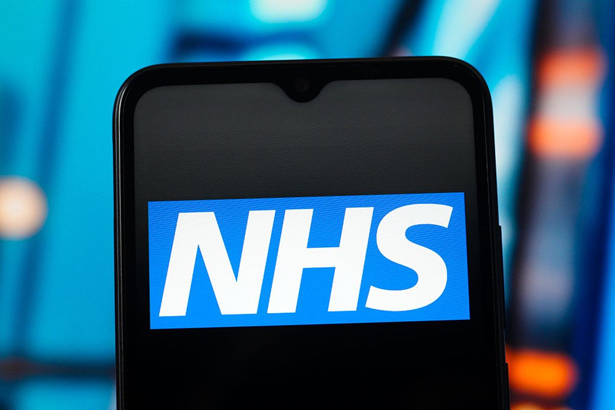 n this photo illustration, the NHS logo is seen displayed on a smartphone screen