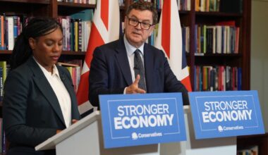 Mel Stride speaking at a press conference, addressing key issues, in a formal setting with a backdrop of the events logo.