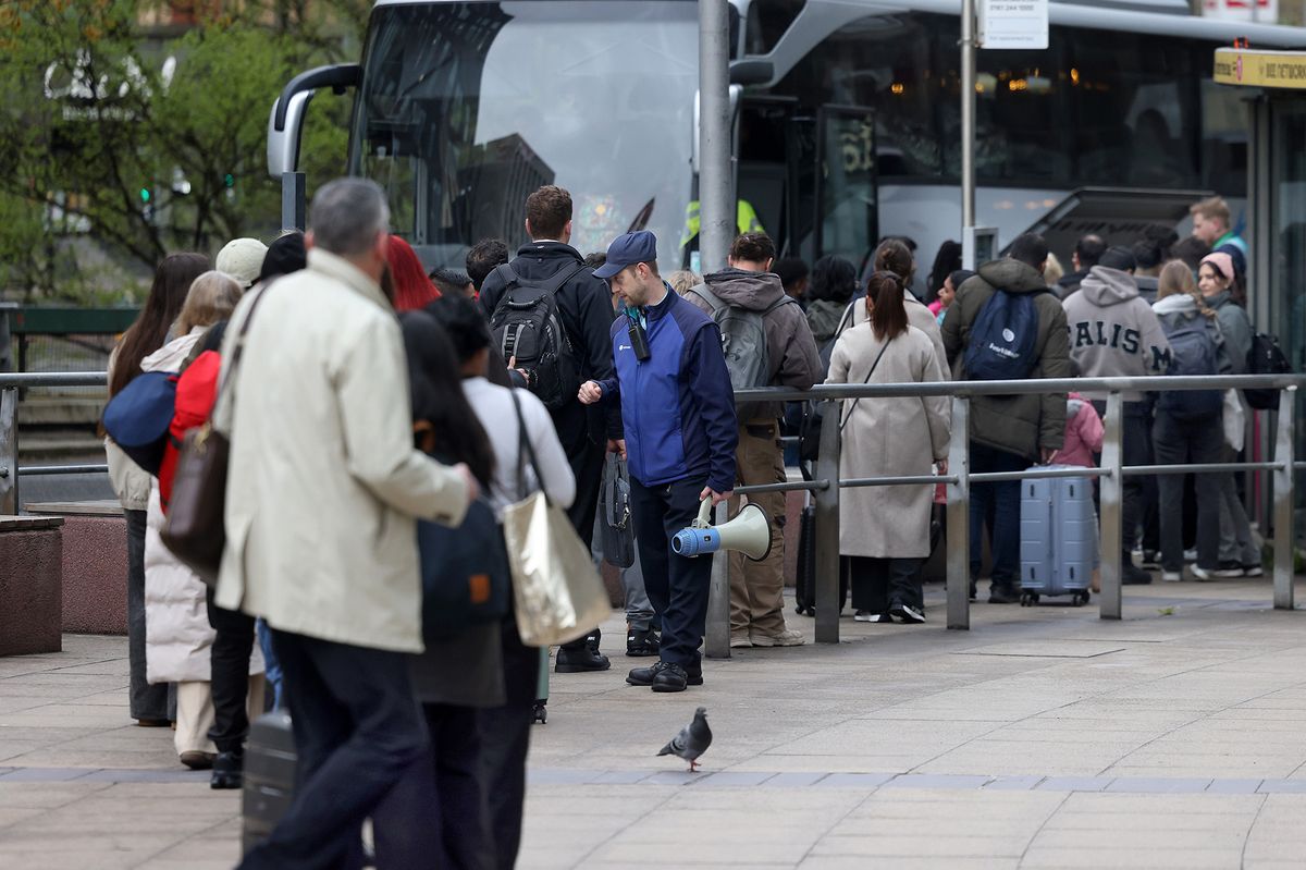 Passengers queue for rail replacement buses outside Piccadilly station on Friday