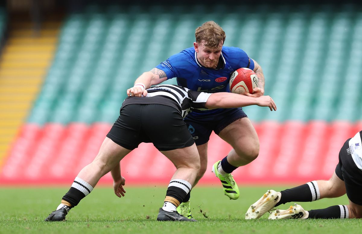 Ellis Dickeson of New Dock Stars is tackled by Iwan Morgan of Tumble