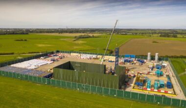 Cuadrilla fracking site with drilling equipment and safety barriers, highlighting energy extraction operations in a rural ...