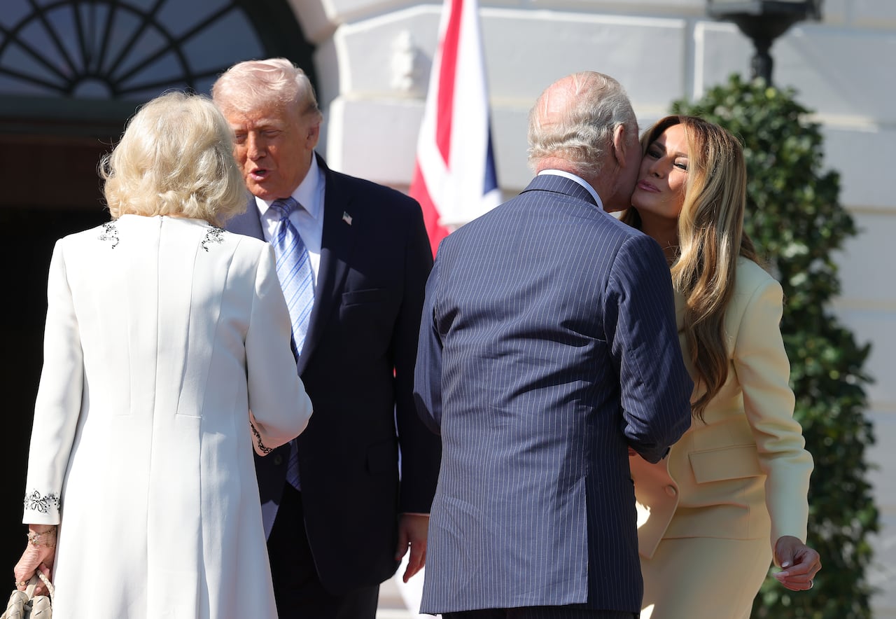 Donald Trump shakes hands with Queen Camilla as first lady Melania Trump leans in to receive a kiss on the cheek from King Charles.