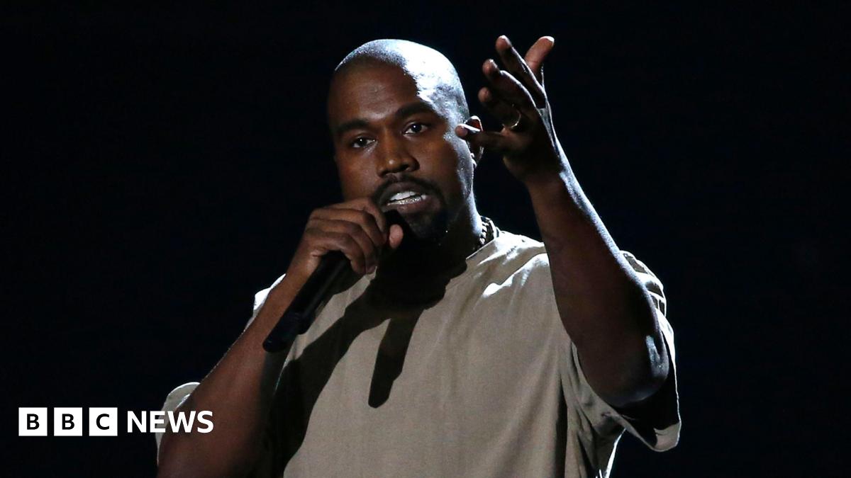 Kanye West on stage holding microphone