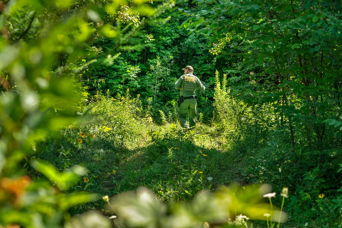 A U.S. Border Patrol agent walks through the woods along the border of Canada and the United States in Houlton, Maine