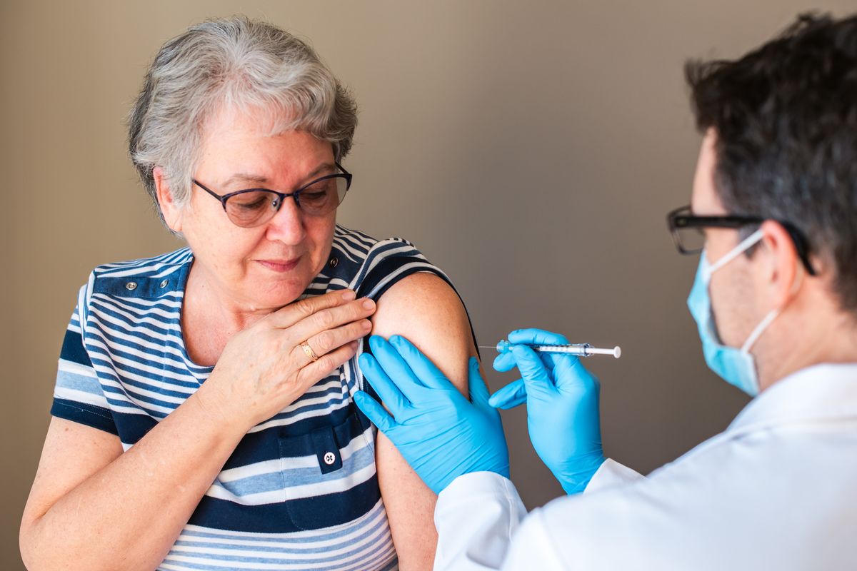 Old woman getting the flu jab in arm
