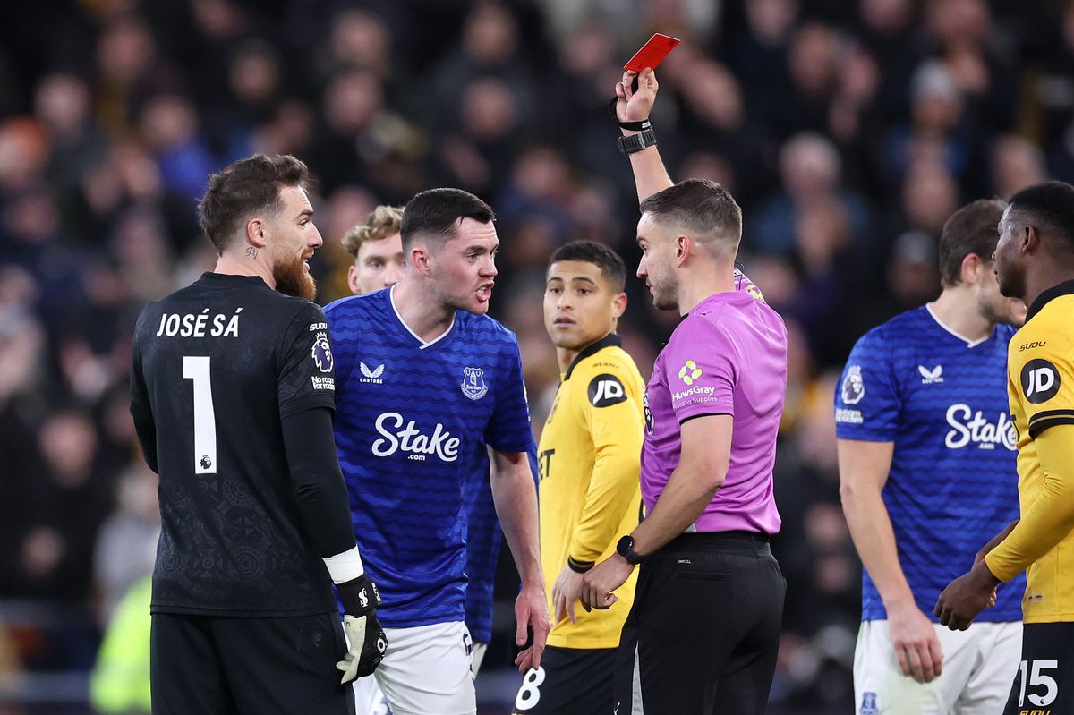 Referee Thomas Kirk shows a red card to Michael Keane