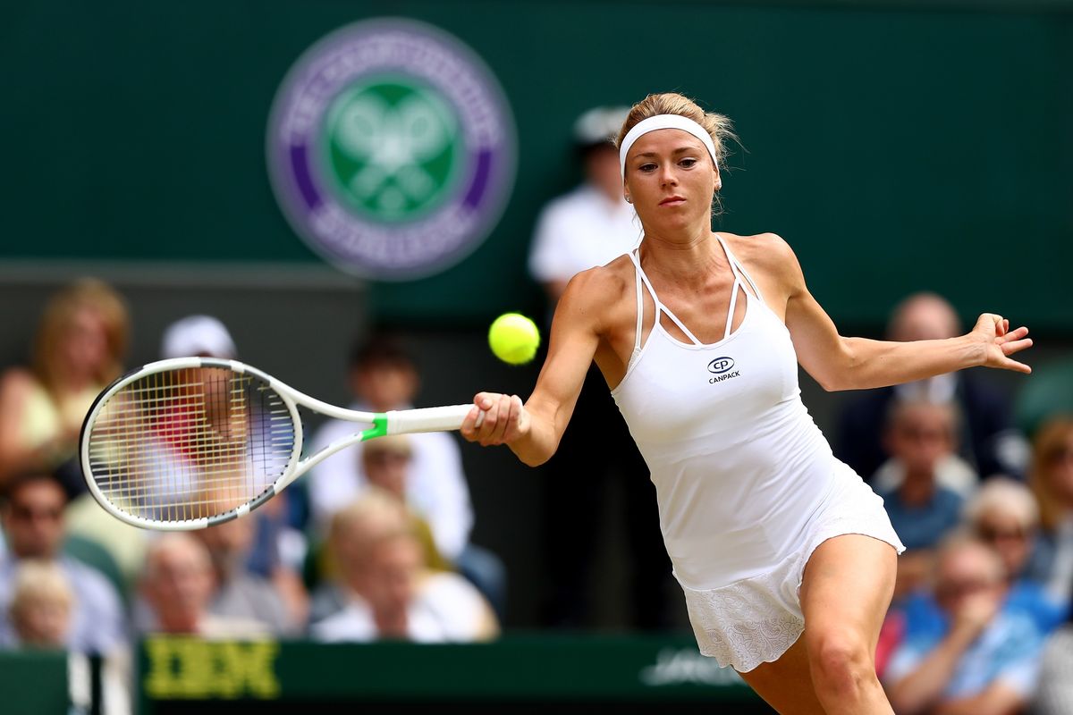 Camila Giorgi of Italy plays a forehand against Serena Williams of the United States during their Ladies' Singles Quarter-Finals match on day eight of the Wimbledon Lawn Tennis Championships at All England Lawn Tennis