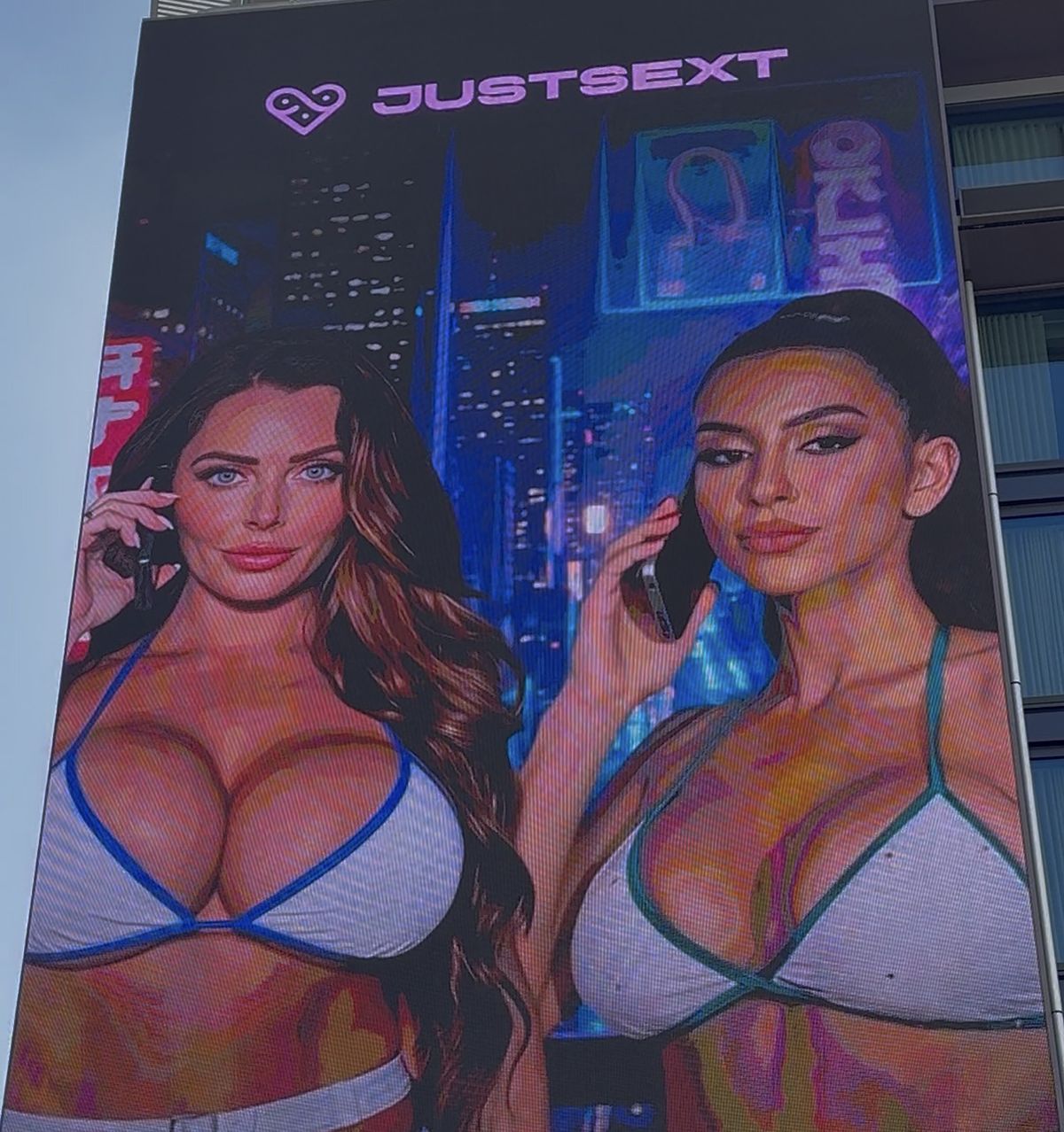 The billboard featuring two bikini-clad AI-generated models chatting suggestively on the phone.