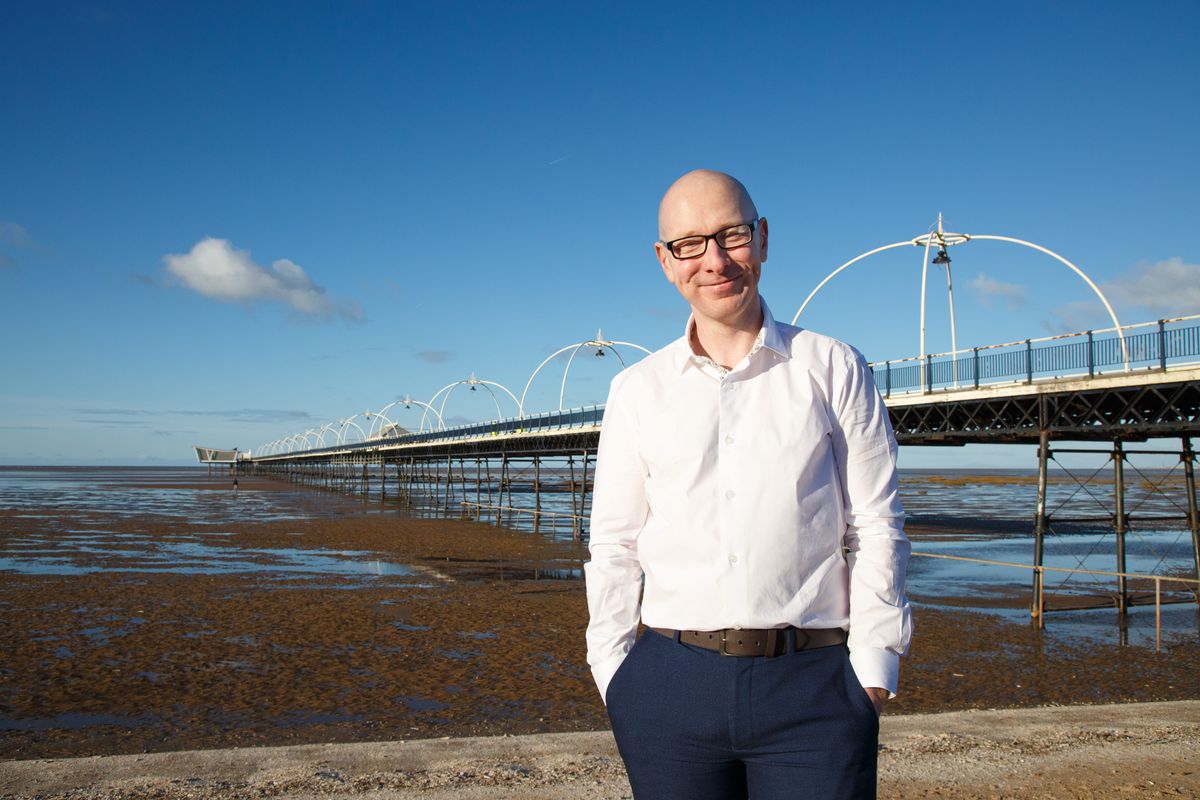 An image of Patrick Hurley MP standing by Southport Pier.
