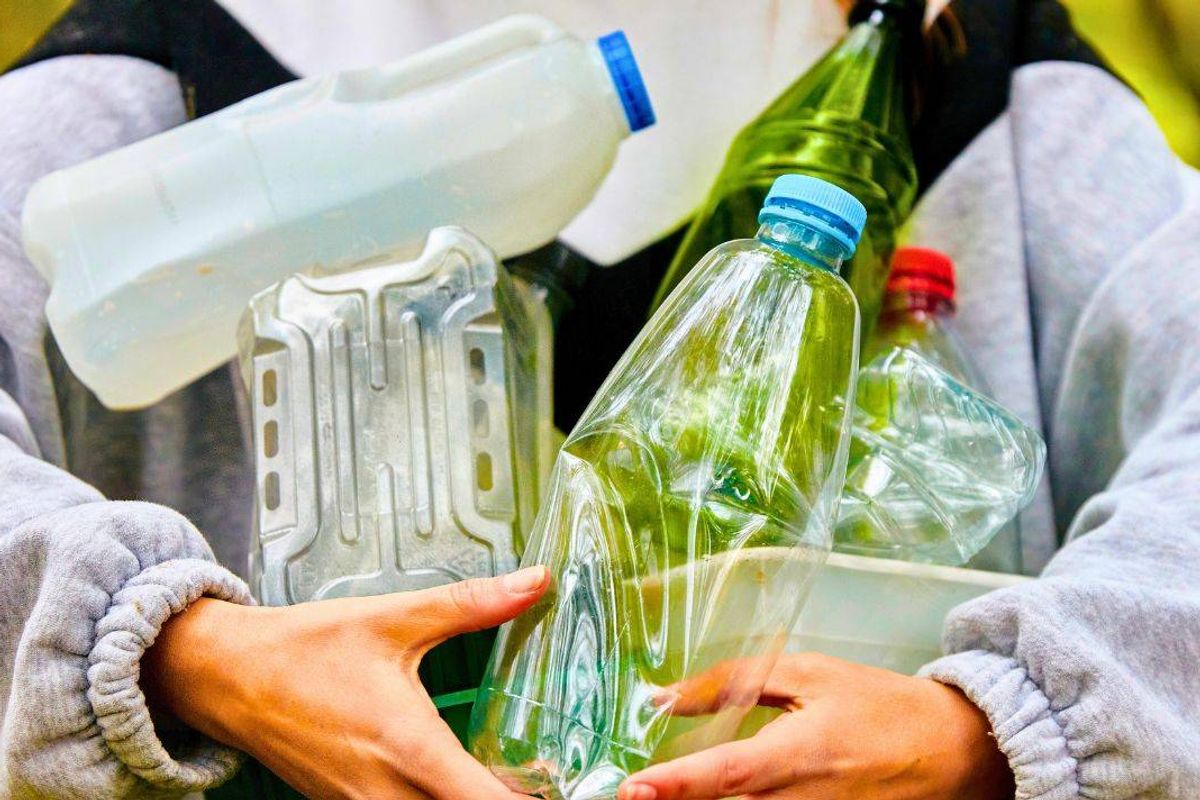 Picture of someone with an armful of recycling