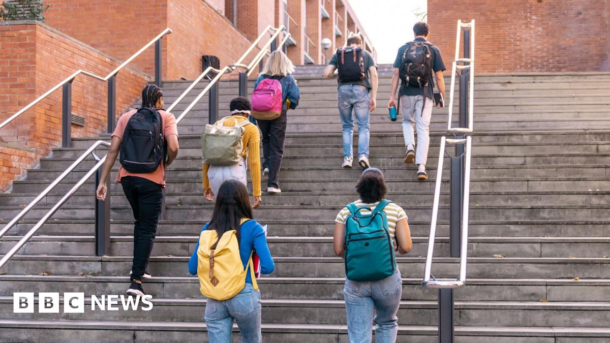 Group of diverse university students walking up outdoor steps, carrying backpacks and heading to classes.