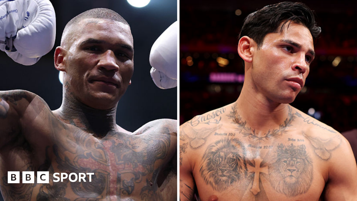 Conor Benn holds up his arms and stands next to Ryan Garcia