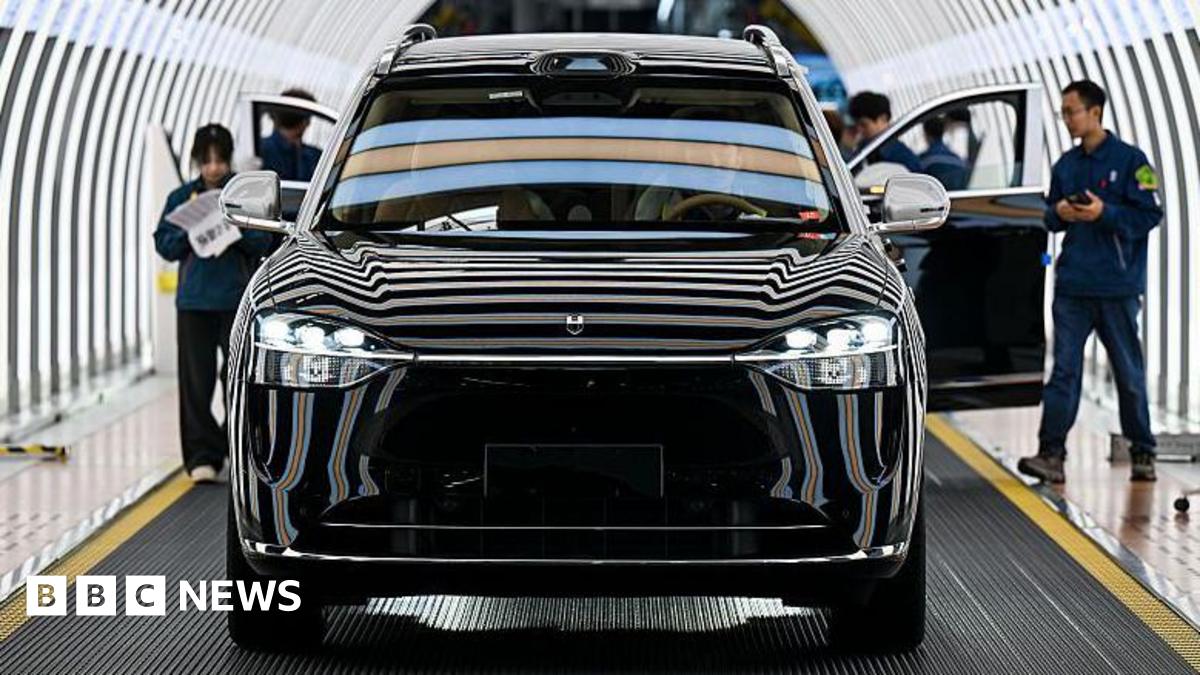 Employees inspects a shiny black Seres electric sports utility vehicle in a production line at factory in China