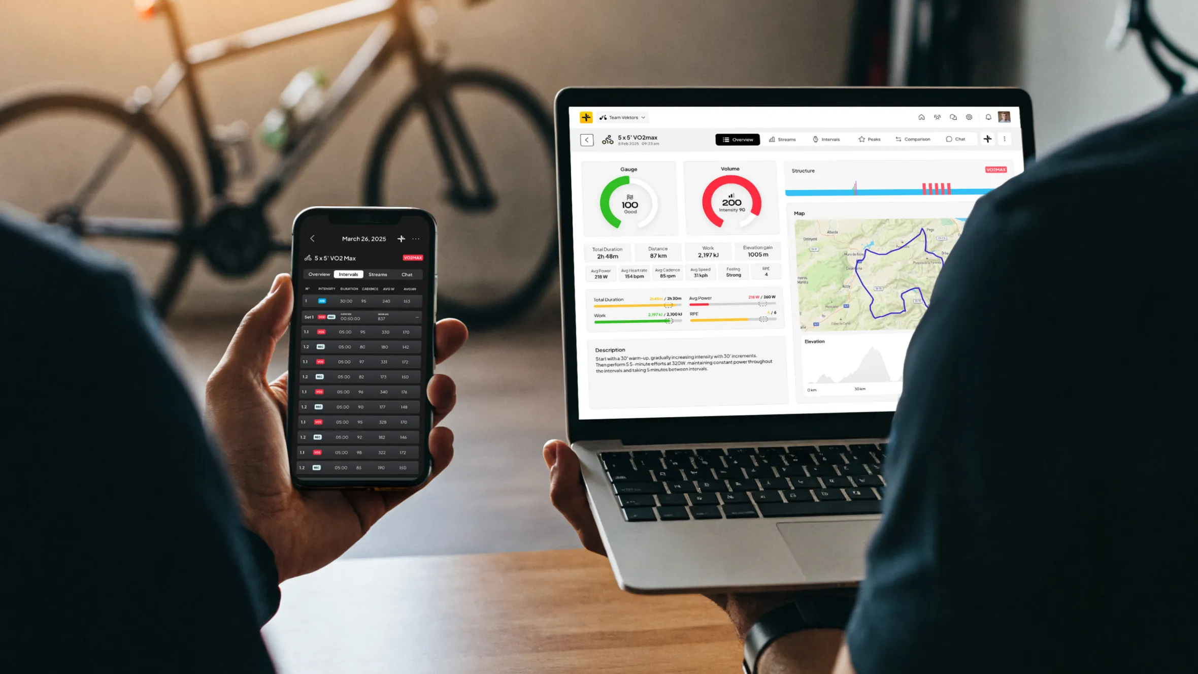 A person viewing their cycling performance data on a smartphone and laptop.