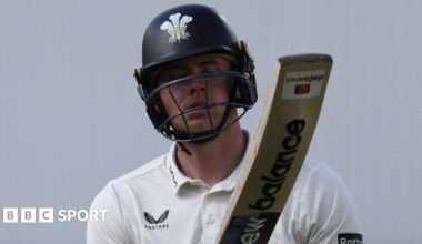 Jamie Smith raises his bat to the crowd