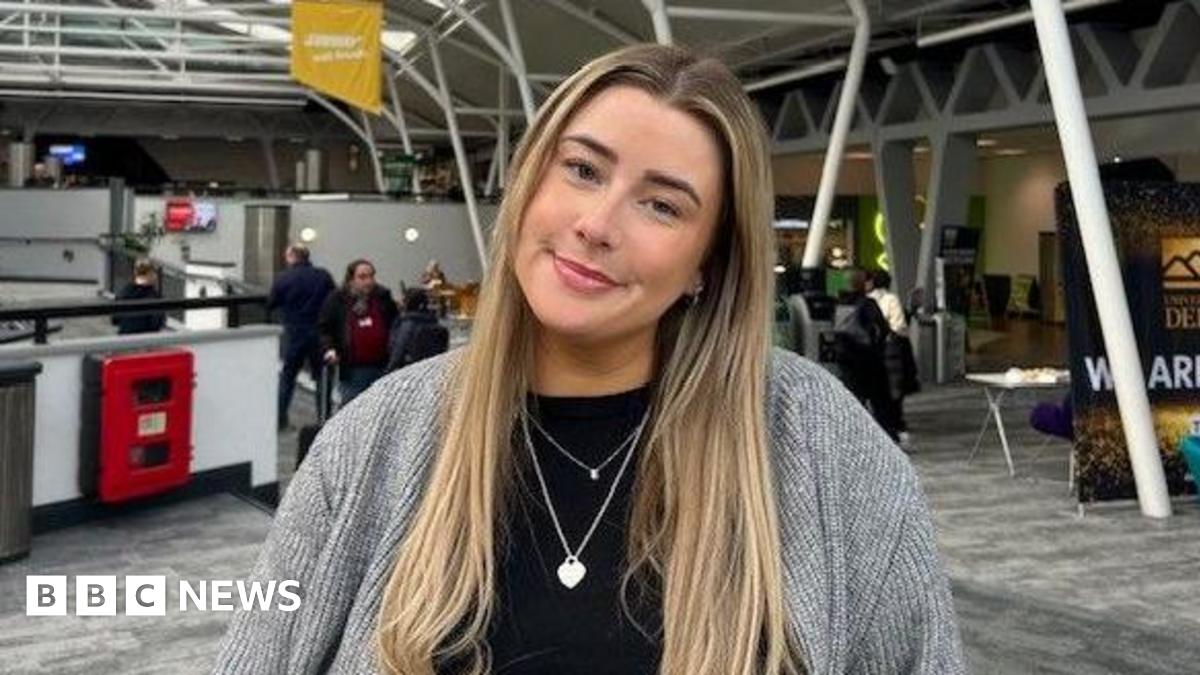 Picture of a white, long haired, blonde, female wearing a grey cardigan with a black top underneath.