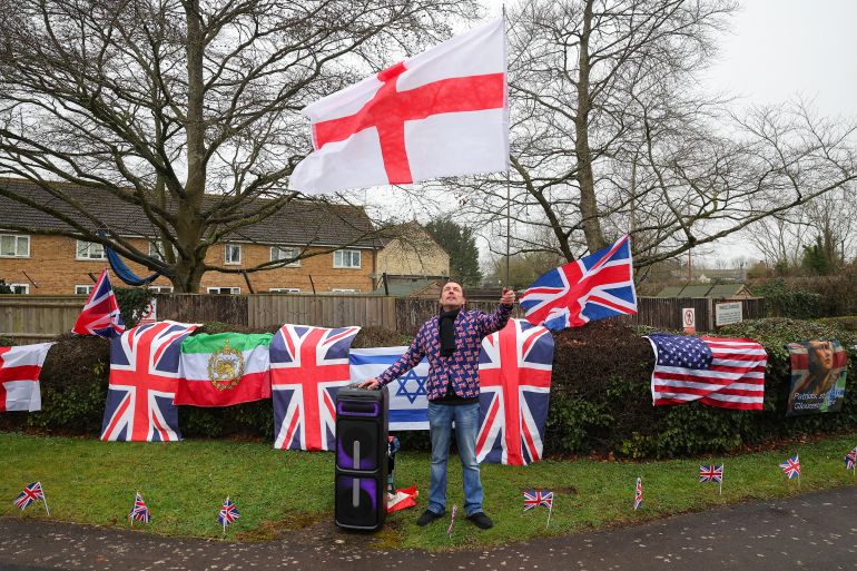 A man who described himself as a 'patriot counter-protester' and supports the U.S. and Israeli operation against Iran, wears a Union Jack-themed jacket while waving an England flag, as anti-war activists protest outside RAF Fairford, which hosts United States Air Force (USAF) personnel, amid the U.S.-Israeli conflict with Iran, in Fairford, Britain, March 7, 2026. REUTERS/Toby Melville