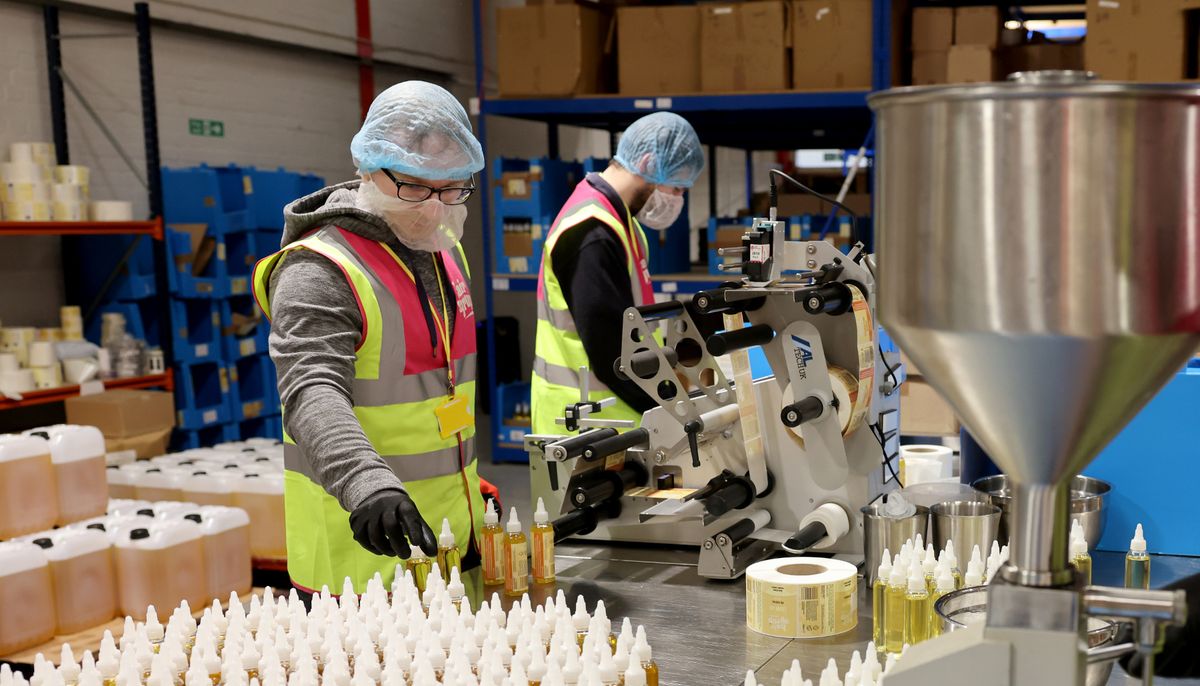 Inside the Hair Syrup industrial unit in Fishguard where people are dressed in work uniform including hair nets and packing bottles