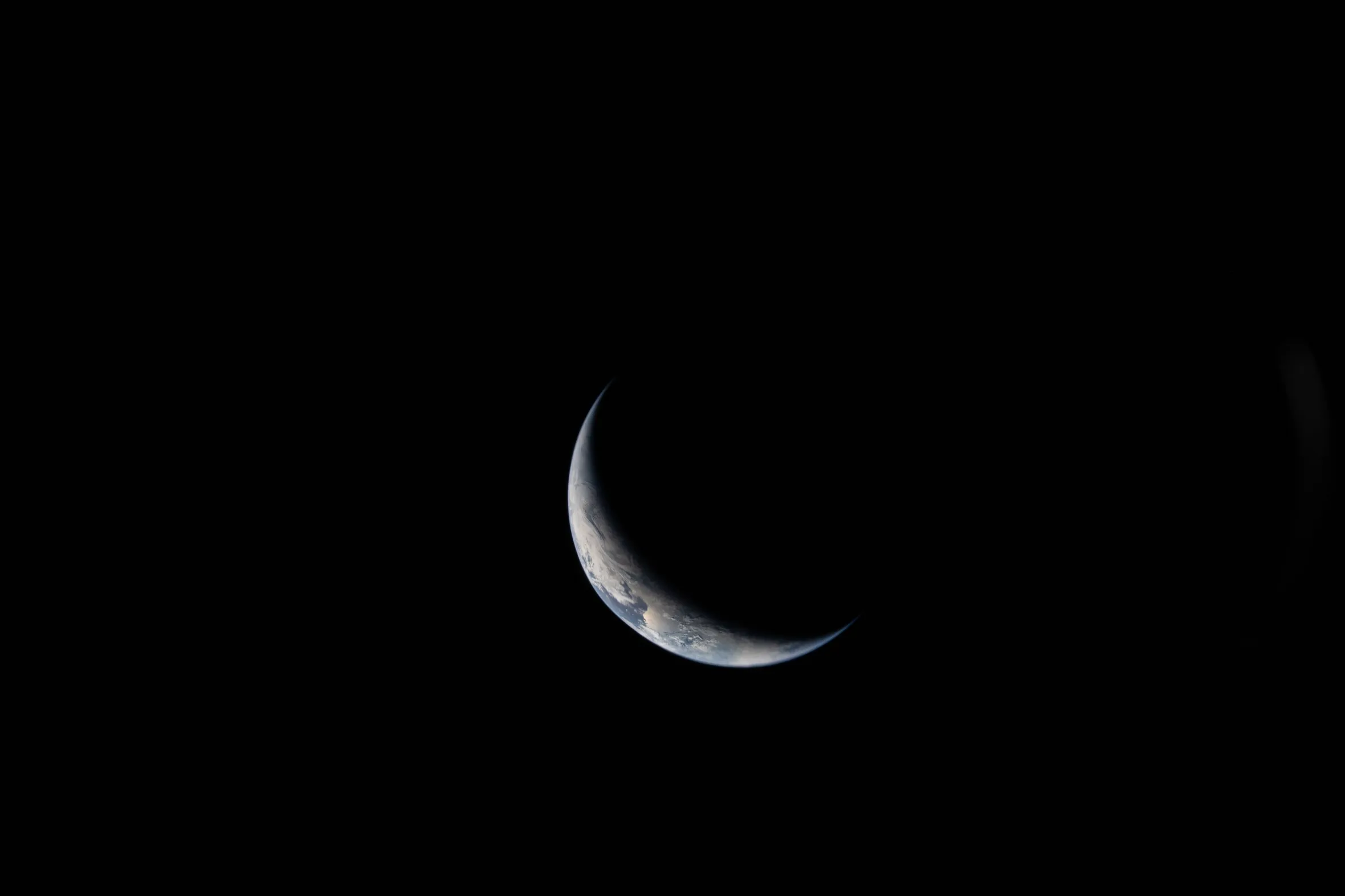 The crescent Earth viewed from space during the Artemis II mission.