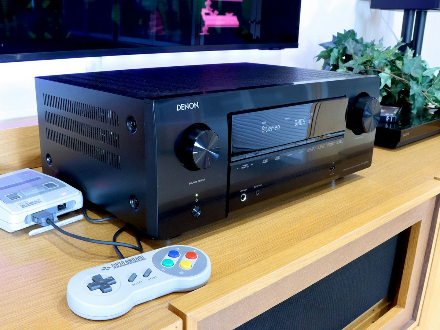 Denon AVR-X2800H Home Cinema Amplifier on a stand with SNES console and blu-ray player in front of a TV