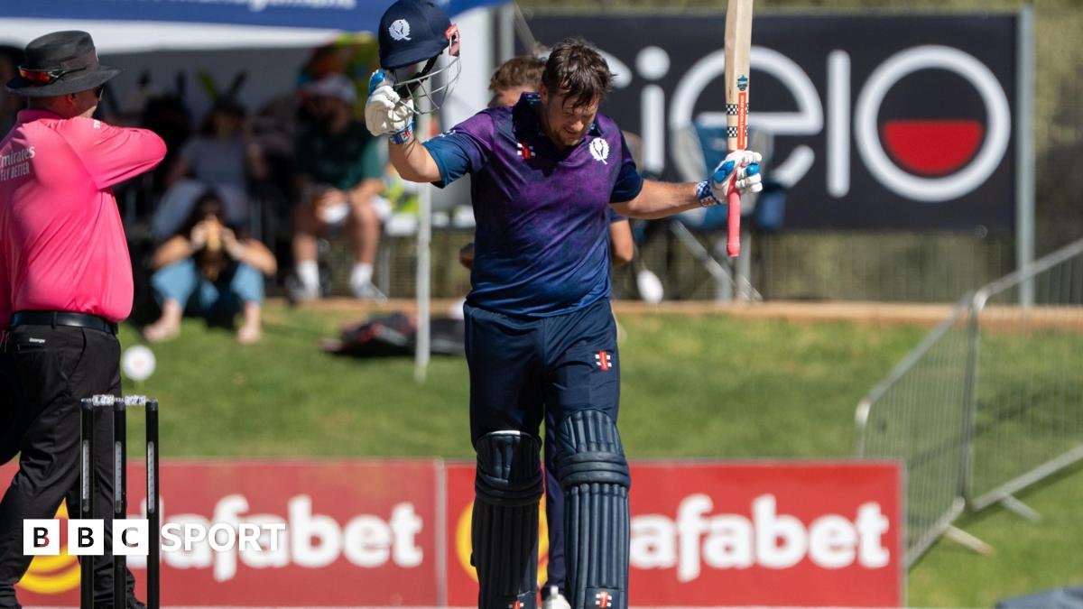 George Munsey raises his bat after reaching three figures