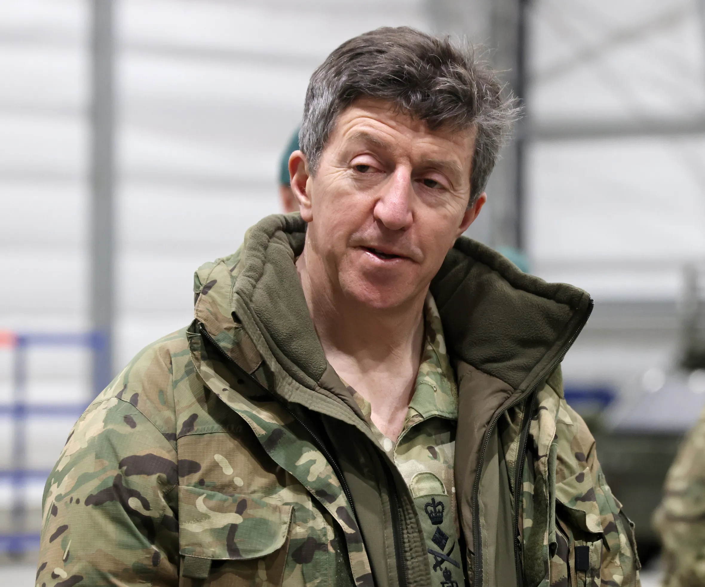 Commandant General Royal Marines, General Gwyn Jenkins, in camouflage, holding a green beret and gloves.