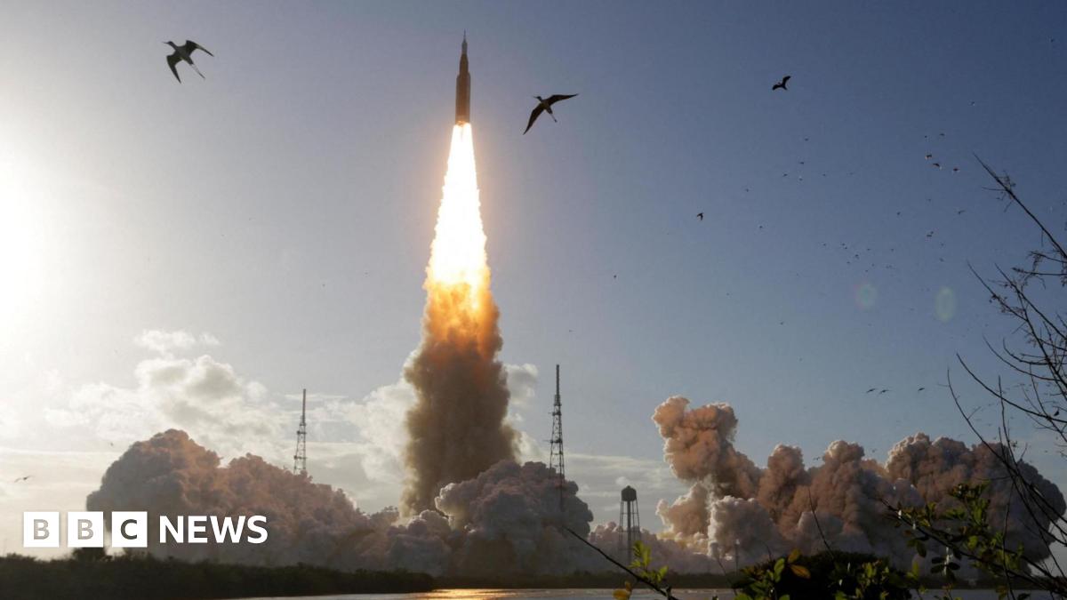 Astronauts pointing at a screen inside the Orion spacecraft