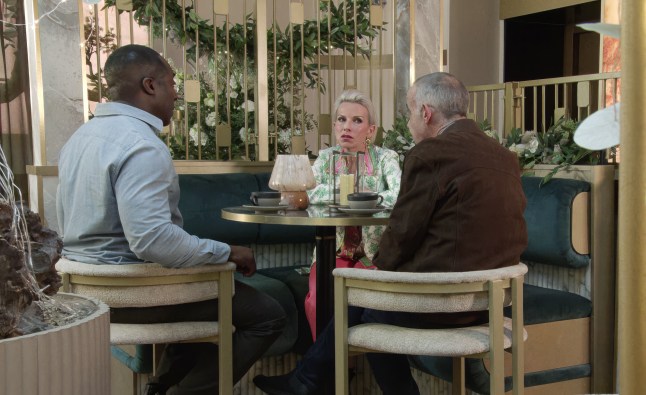 Debbie sits around a table with Ronnie and KEvin
