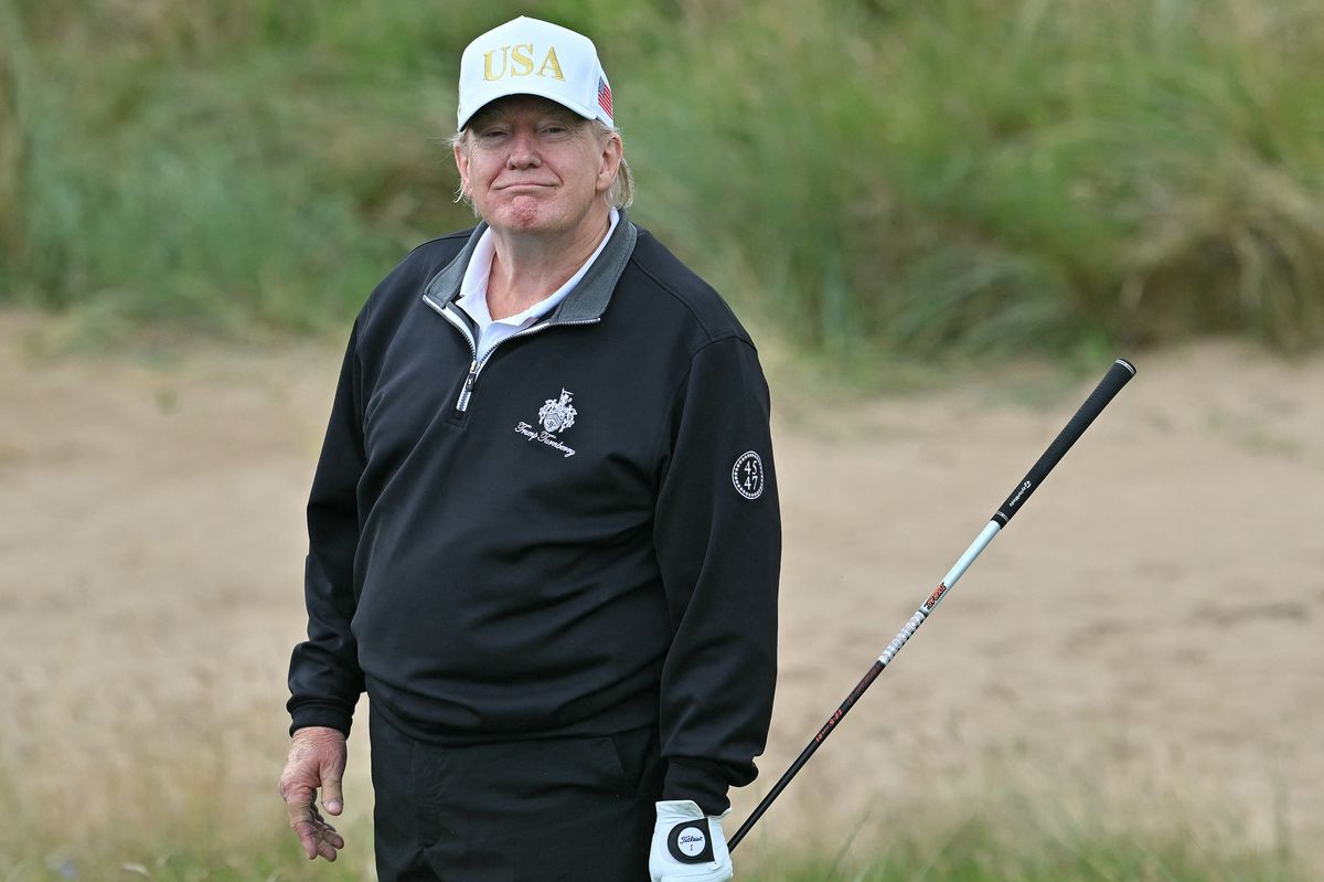 US President Donald Trump reacts after playing from the first tee to officially open the Trump International Golf Links course in Balmedie