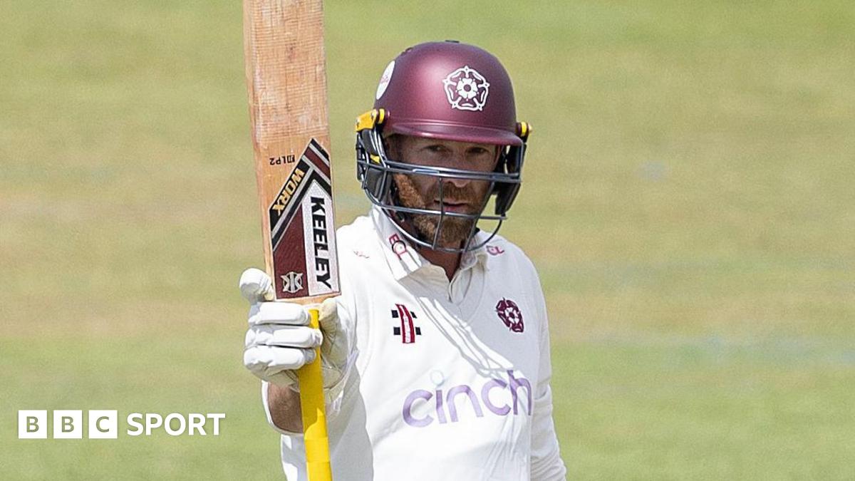 Luke Procter raises his bat during an innings for Northamptonshire