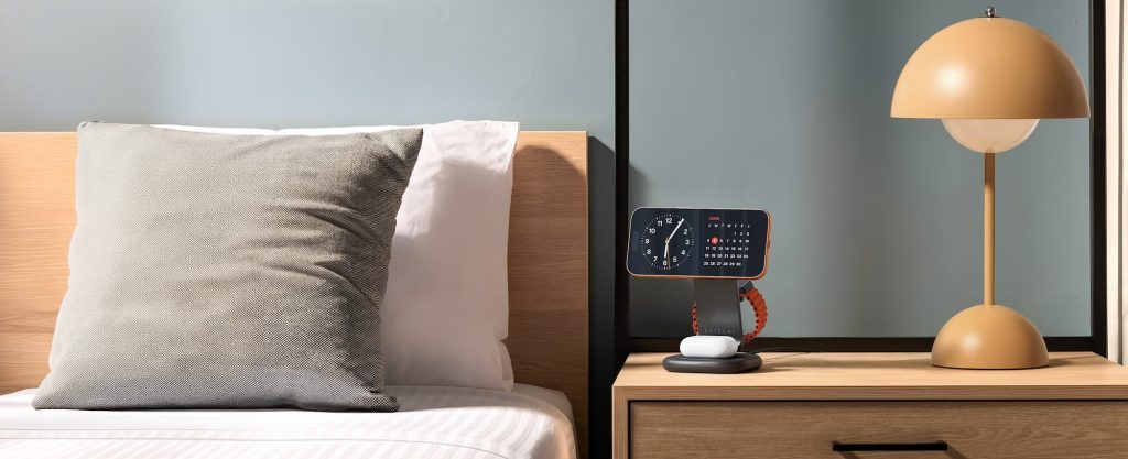 A device on a nightstand next to a bed