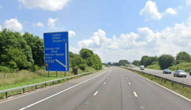 The M4 near Swindon. It has three lanes and there is a blue road sign on the left.