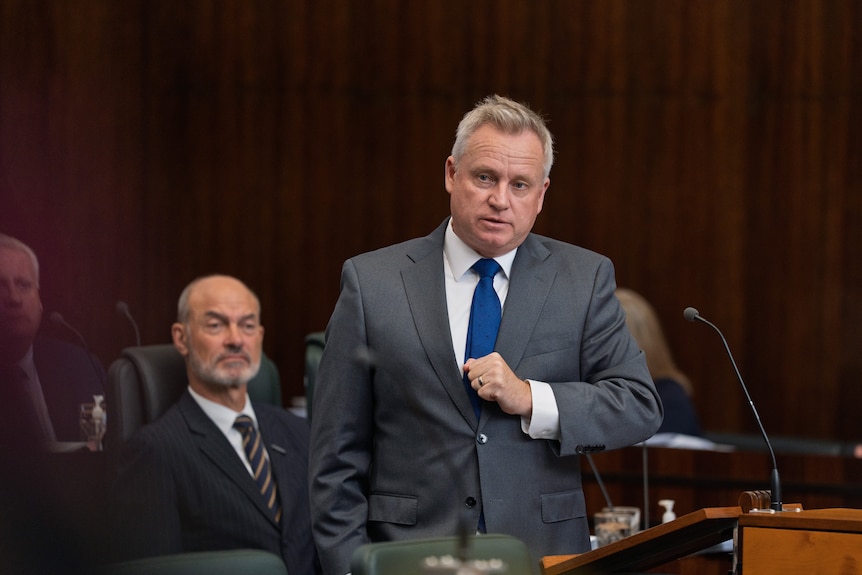 A man in a suit talks in parliament